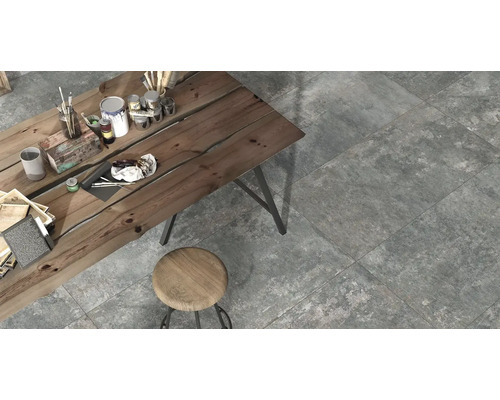 Sivé dlaždice v interiéri s dreveným stolom a stoličkou.