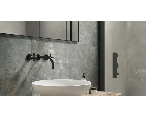 Moderná kúpeľňa s umývadlom, vodovodnou batériou, zrkadlom a sivými obkladmi.