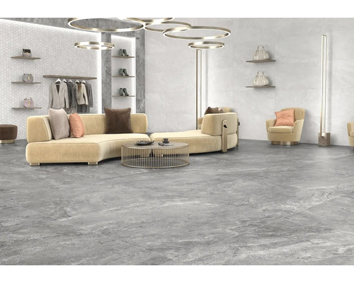 Svetlá miestnosť s podlahovými dlaždicami s kamenným vzhľadom, pohovka, kreslo a dekorácie