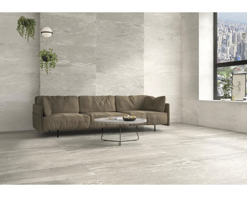 Svetlá obývacia izba s obkladmi stien a podláh imitujúcimi mramor, pohovka a stôl