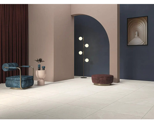 Svetlá miestnosť s dlažbou, kreslom, stojacou lampou a dekoráciou