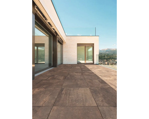 Terasa s hnedými dlaždicami a skleneným zábradlím za slnečného dňa