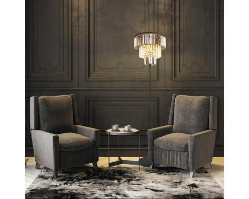 Obývacia izba s dvomi kreslami, odkladacím stolíkom, stojacou lampou a vzorovaným kobercom.