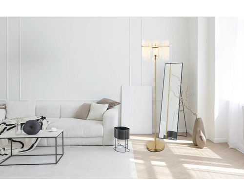 Svetlá obývacia izba s pohovkou, stojacou lampou a zrkadlom