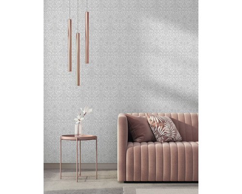 Obývacia izba so vzorovanou tapetou, pohovkou, stolom a závesnými lampami