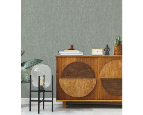 Obývacia izba s tapetou so vzorom, príborníkom a dekoratívnymi prvkami.