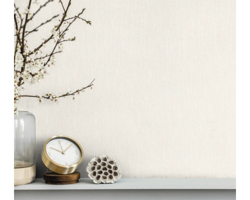 Dekoratívne aranžmán s vázou, kvitnúcimi vetvami, stolovými hodinami a sušeným kvetom lotosu na poličke.