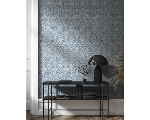 Pohľad do miestnosti s tapetou so vzorom, konzolou, knihami a dekoráciou