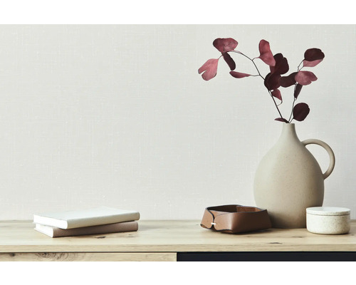 Dekorácia s vázou, sušenými kvetmi, hromadou kníh a úložným boxom na stole