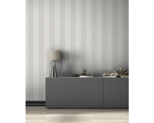 Obývacia izba s pruhovanou tapetou, príborníkom a stolnou lampou