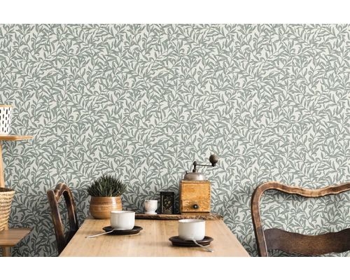 Obývacia izba so vzorovanou tapetou s listami a dreveným stolom
