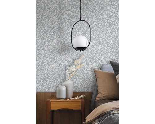 Spálňa s tapetou so vzorom listov, nočným stolíkom a lampou