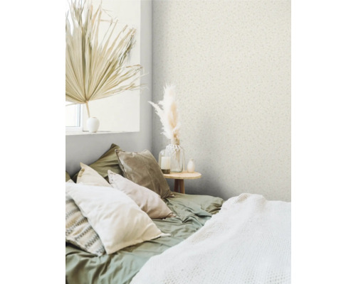 Spálňa s tapetou so vzorom, posteľou s vankúšmi a dekoráciami.