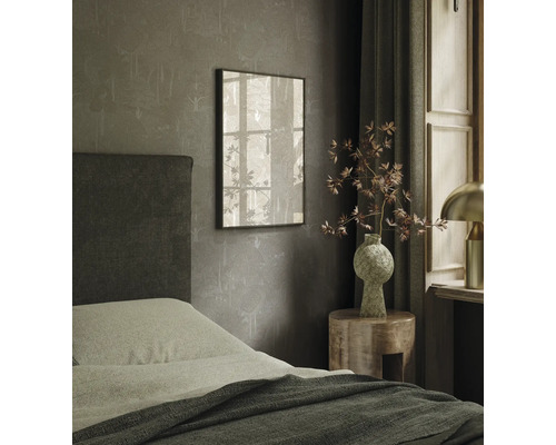 Spálňa s posteľou, nočným stolíkom a zarámovaným obrazom na stene