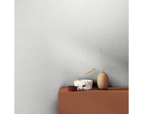 Svetlá tapeta s ľanovou štruktúrou a dekoratívnymi predmetmi