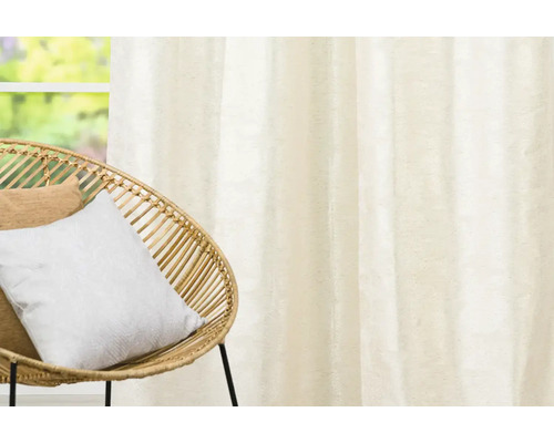 Interiérová scéna s ozdobnými šálmi a ratanovým kreslom.