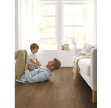 Otec a dieťa sa hrajú na drevenej podlahe v svetlej obývacej izbe.