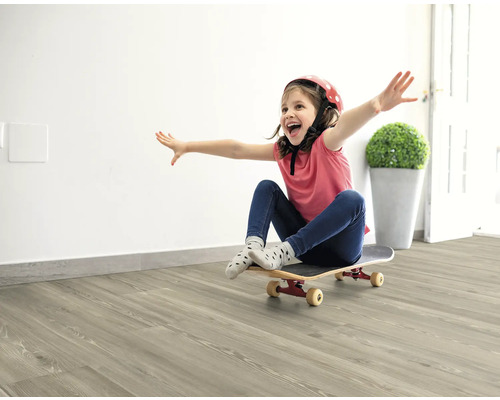 Dievča s helmou a skateboardom na svetlej drevenej podlahe