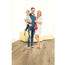 Rodina s dieťaťom a červeným ukulele na drevenej podlahe vo svetlej miestnosti