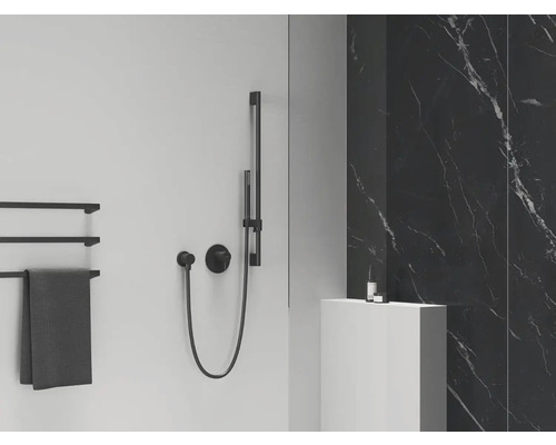 Sprchový systém s ručnou sprchou, držiak na uteráky a umývadlo v kúpeľni.