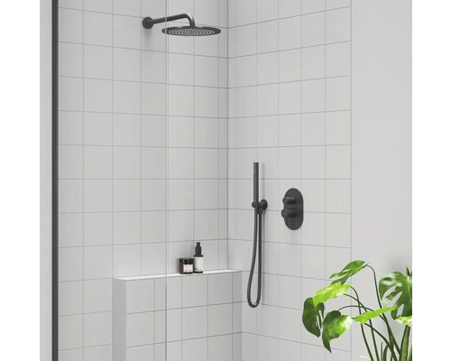 Sprchovací kút so stropnou sprchou, ručnou sprchou a batériou pred stenou s bielymi obkladmi