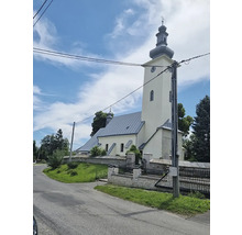 Vonkajší pohľad na kostol s vežou a okolitou krajinou