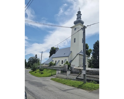 Vonkajší pohľad na kostol s vežou a okolitou krajinou