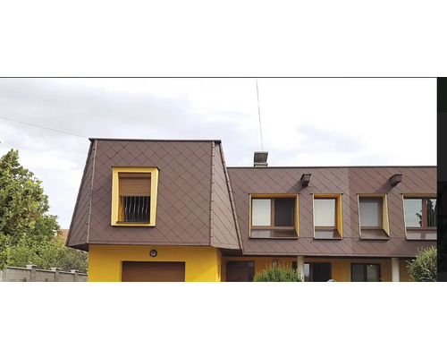 Fasáda domu s hnedou strechou a žltými okennými rámami