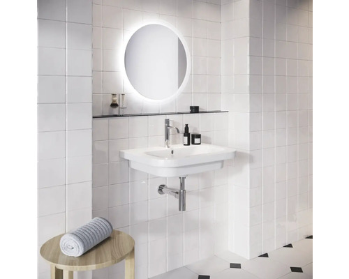 Kúpeľňa s umývadlom, okrúhlym zrkadlom s osvetlením a stenou z bielych dlaždíc