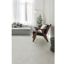 Svetlá obývacia izba s pohovkou, kreslom, stojacou lampou a izbovou rastlinou