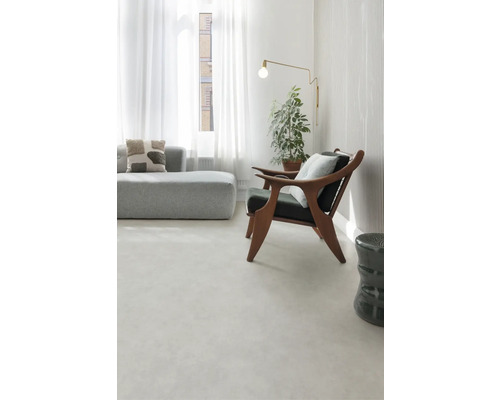 Svetlá obývacia izba s pohovkou, kreslom, stojacou lampou a izbovou rastlinou