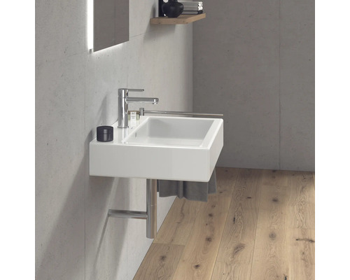 Moderná kúpeľňa s bielym umývadlom, batériou a držiakom na uteráky