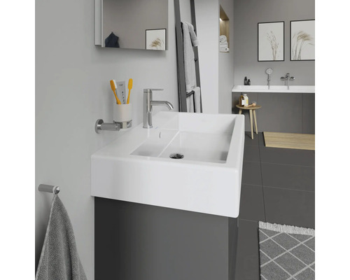 Moderná kúpeľňa s umývadlom, batériou, zrkadlom a držiakom na uteráky.