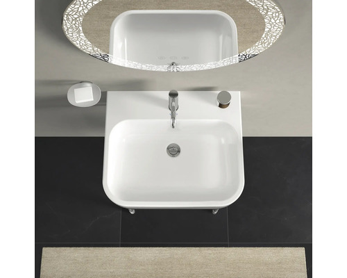 Pohľad zhora na umývadlo s batériou, mydelničkou a osvetleným zrkadlom v kúpeľni.