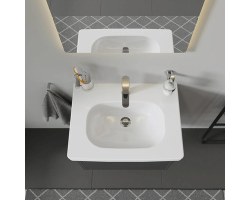 Pohľad zhora na kúpeľňu s umývadlom, batériou, uterákom a doplnkami.