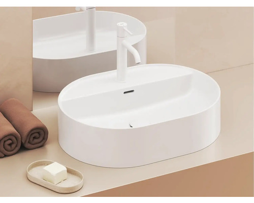 Na umývadle sa nachádza oválne umývadlo na dosku, vodovodná batéria, uteráky a mydlo.