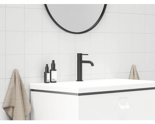 Moderná kúpeľňa s umývadlom, batériou, zrkadlom a uterákmi