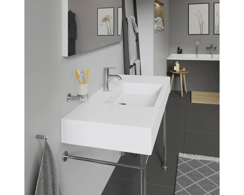 Moderná kúpeľňa s bielym umývadlom, držiakom na uteráky a zrkadlom