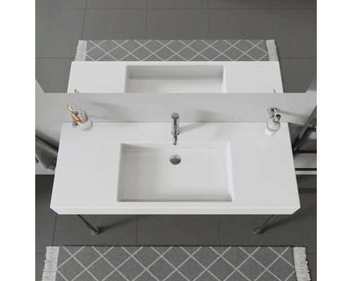 Pohľad zhora na kúpeľňu s bielym umývadlom a sivým kobercom