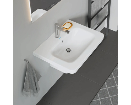 Biele umývadlo na dosku s vodovodnou batériou, mydelničkou a držiakom na uteráky v kúpeľni.