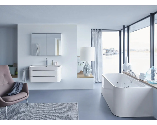 Svetlá kúpeľňa s umývadlom, zrkadlovou skriňou, vaňou a kreslom pre modernú atmosféru.