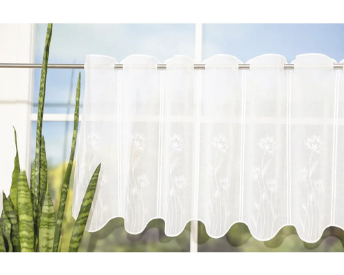 Záclona s kvetinovým vzorom pred oknom