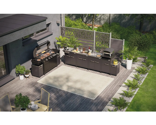 Pohľad zhora na vonkajšiu kuchyňu s grilom, drezom, pecou na pizzu a pracovnými plochami na drevenej terase