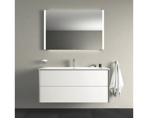 Kúpeľňová scéna s umývadlovou skrinkou, zrkadlom s osvetlením, držiakom na mydlo a držiakom na uteráky.