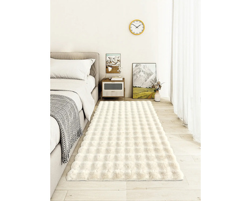 Spálňa s posteľou, nočným stolíkom a obdĺžnikovým kobercom