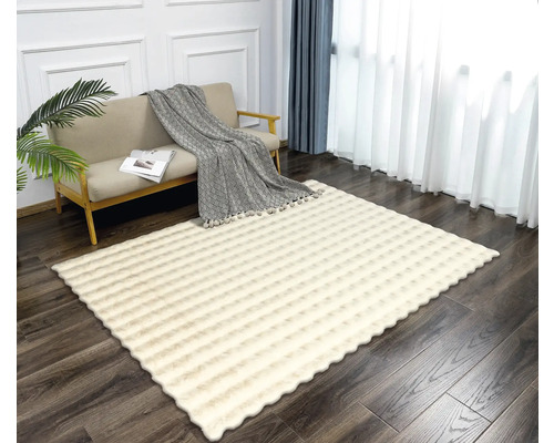 Obývacia izba s pohovkou a vzorovaným obdĺžnikovým kobercom.