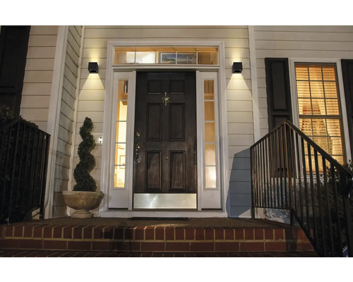 Vstupný priestor domu s vchodovými dverami a vonkajšími nástennými svietidlami.