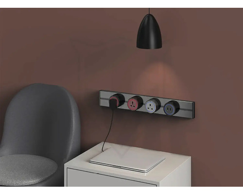 Nástenná zásuvková lišta s niekoľkými zásuvkami nad nočným stolíkom