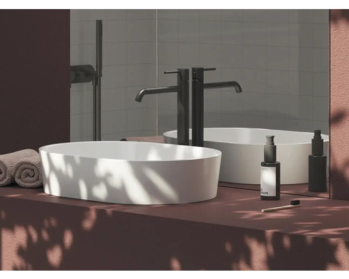 Moderné umývadlo v kúpeľni s batériou, uteráky a ošetrujúce produkty