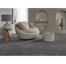 Interiérová fotografia obývacej izby so sivým kobercom, kreslom, stolom a dekoratívnymi prvkami